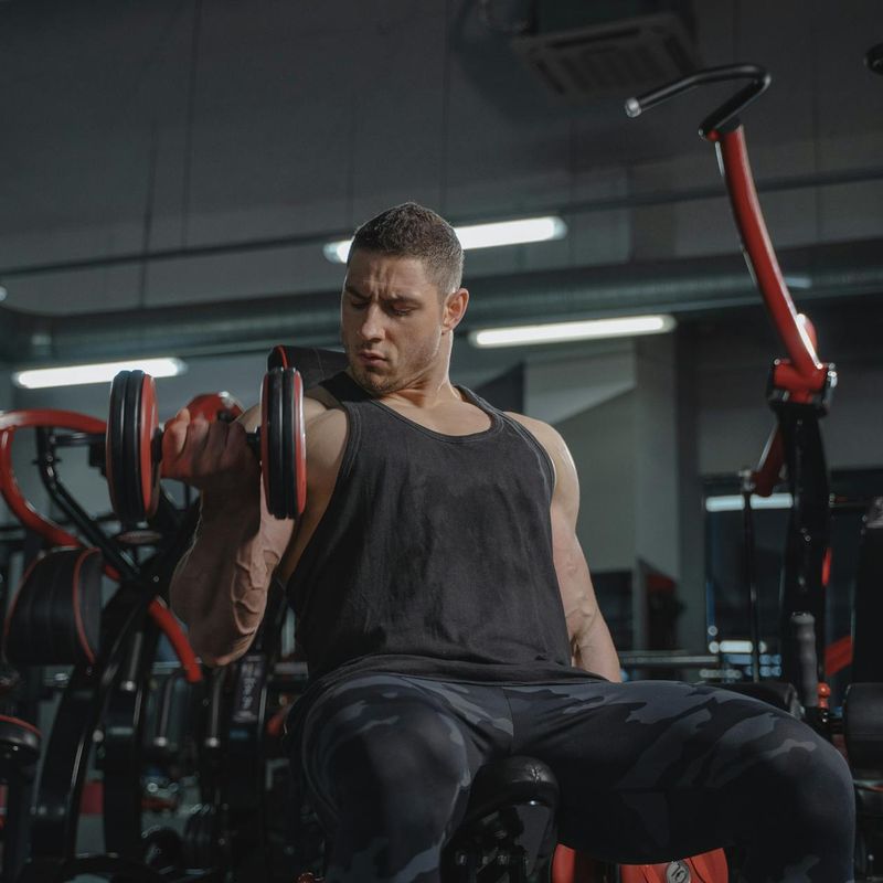 Athletic man lifting weights in a modern industrial gym